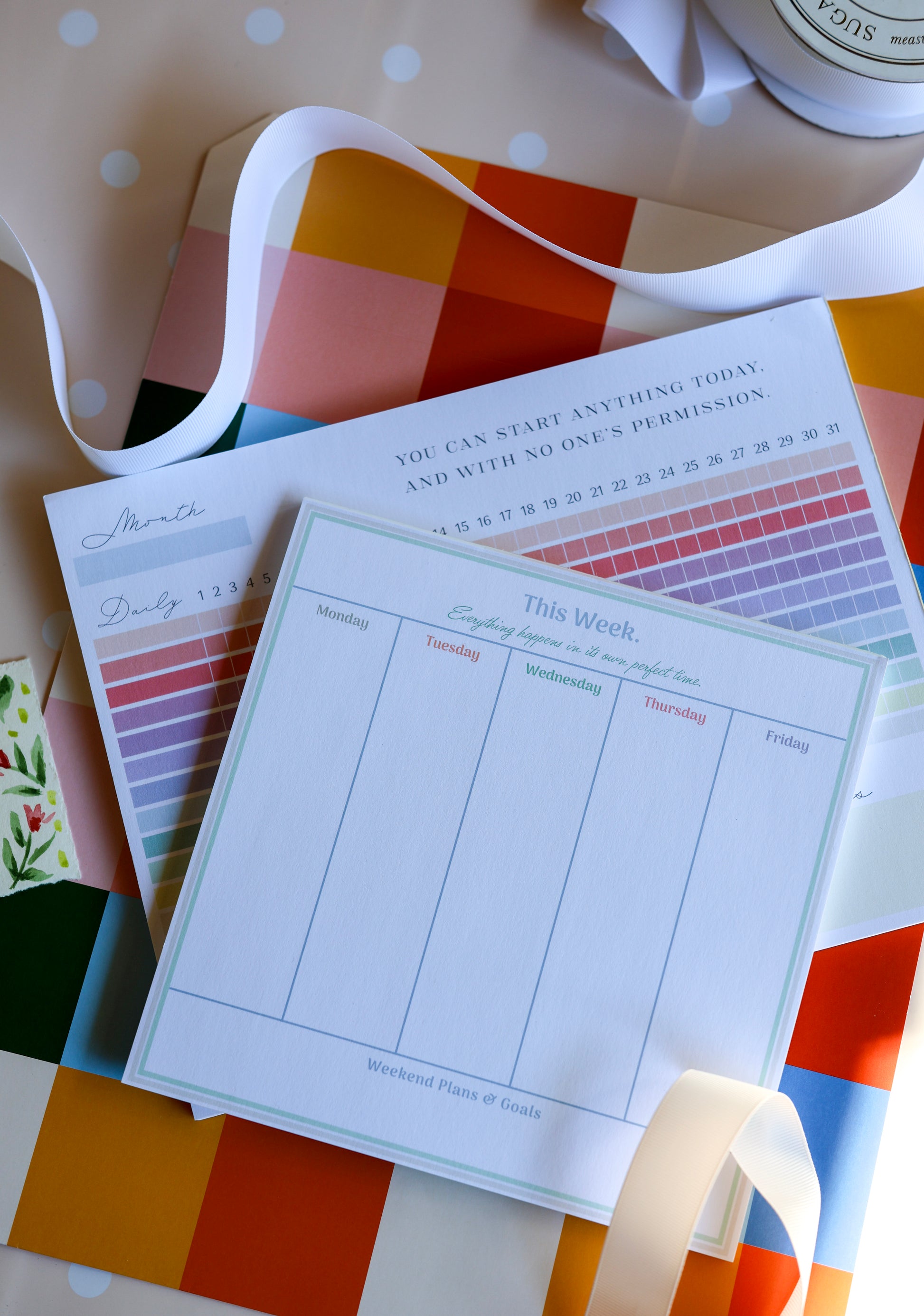 Styled photo of The Gift Set stationery duo — habit tracker and weekly planner tied with ribbon.