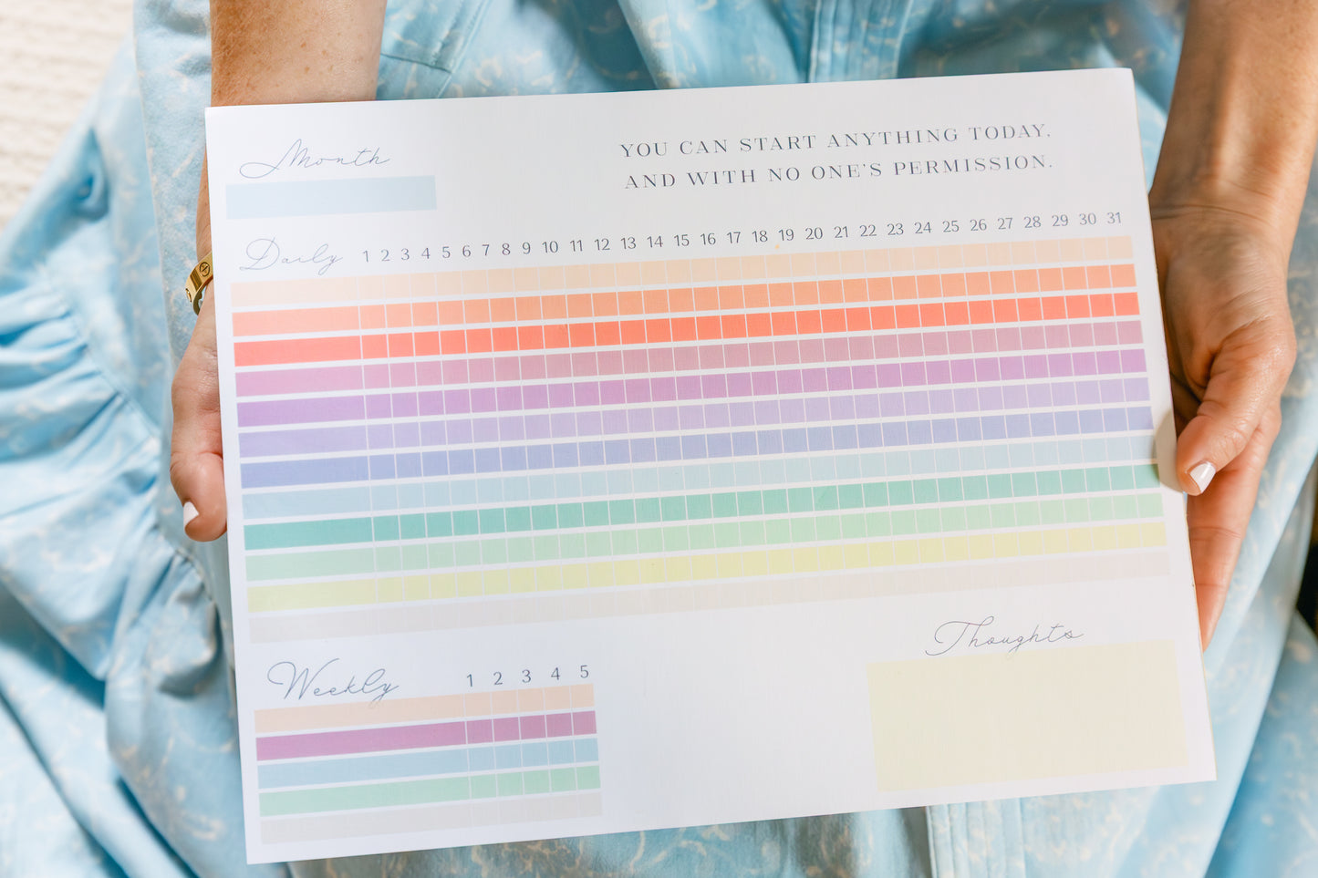 Magpie x Mamey habit tracker pad with rainbow design held by person wearing a blue dress