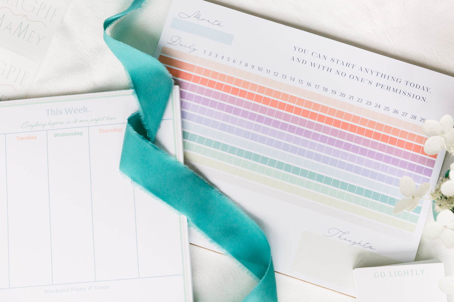Magpie x Mamey habit tracker with rainbow grid styled alongside weekly planner and ribbon