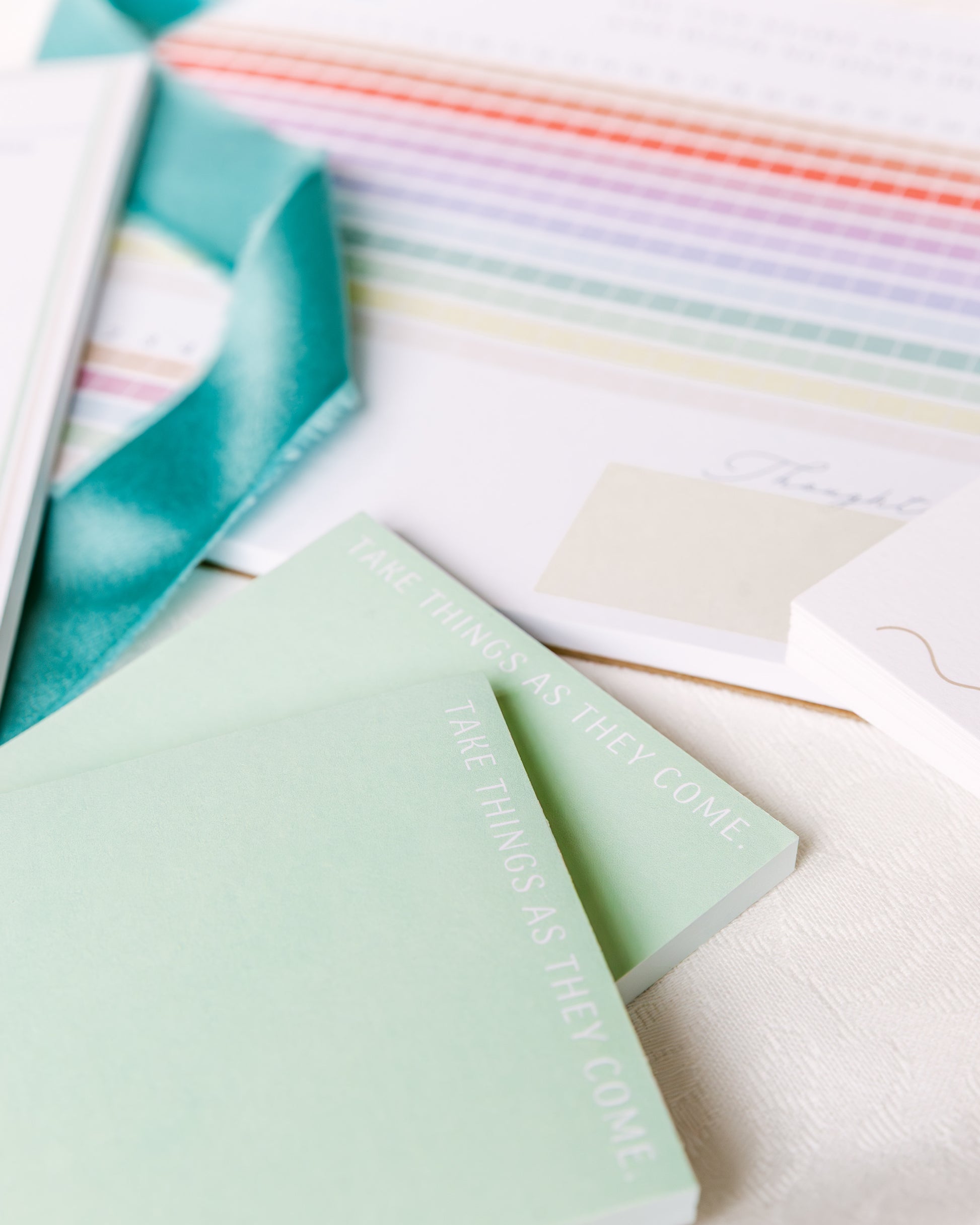 Magpie x Mamey colorblocked notepad with “Take Things As They Come” text, styled with ribbon and habit tracker