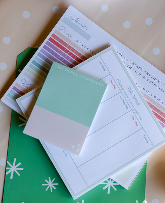 Flat lay of The Productivity Trio bundle showing pastel planner, notepad, and habit tracker.